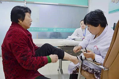 中医科医生张亚芬亲自为患者检查病情